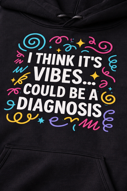 Close-up of the colourful DTG print on a black hoodie reading “I think it’s vibes… could be a diagnosis,” showing texture and vibrant detail.