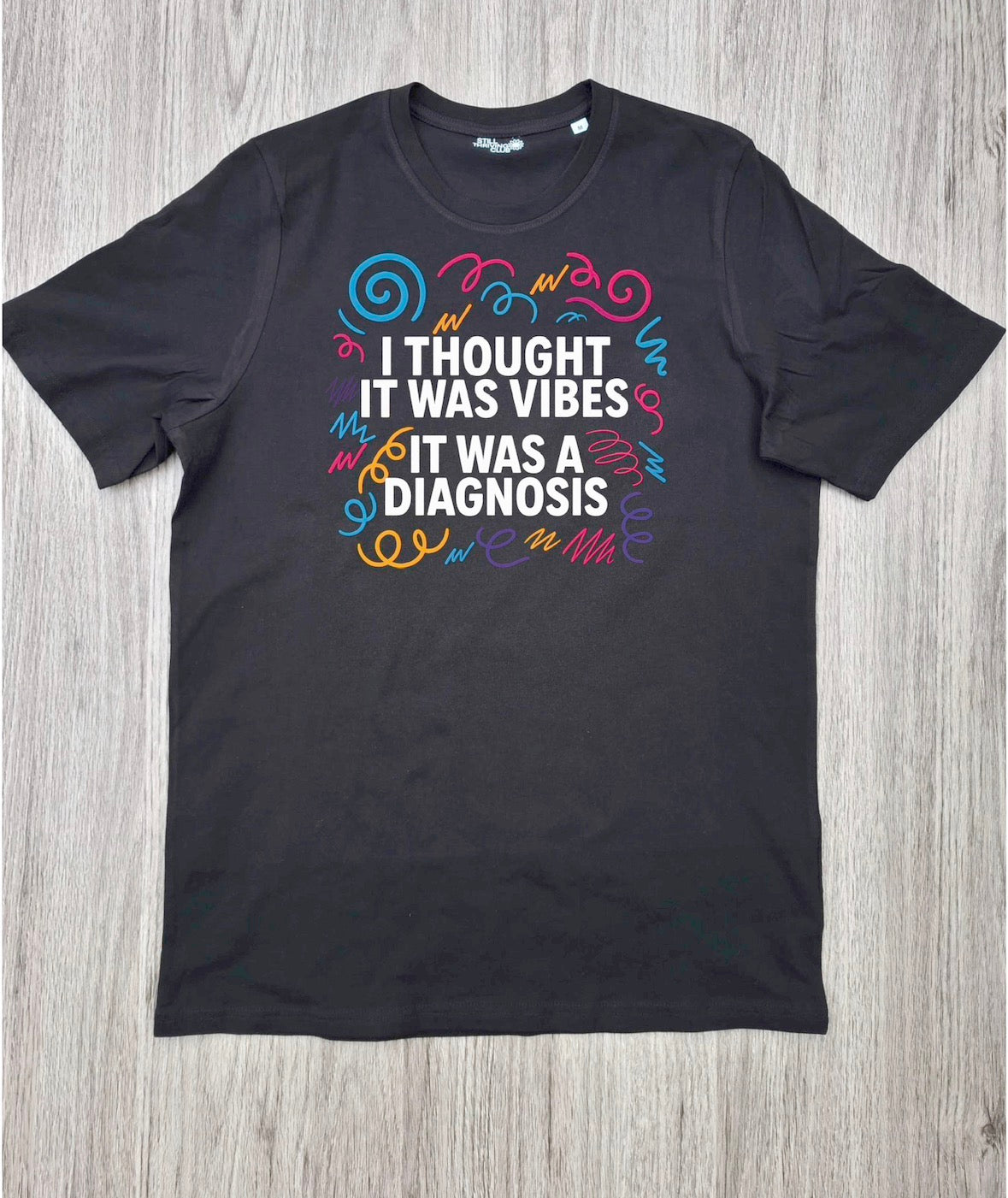 I Thought It Was Vibes ADHD T-shirt flat lay on wooden surface