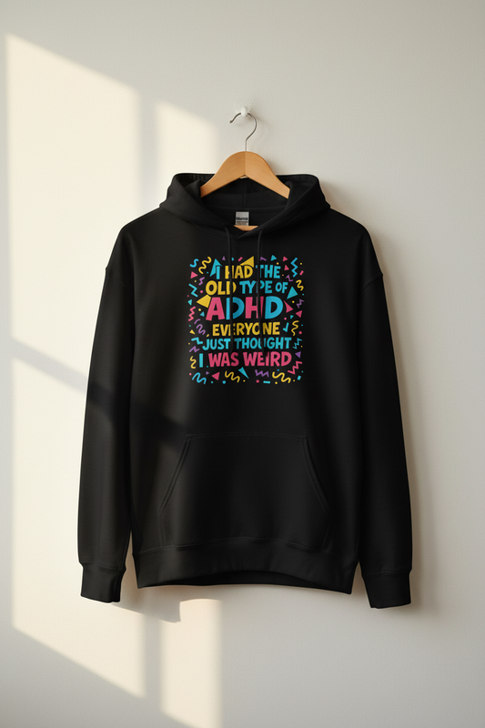 Black ADHD graphic hoodie hanging on a wooden hanger against a light wall